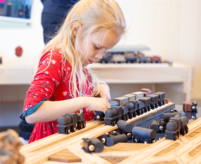 girl assembling a train track