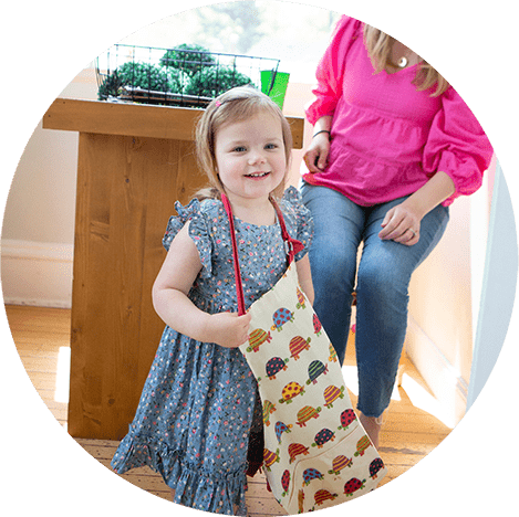 girl in an apron playing with her mom