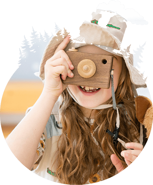 girl playing with a wooden toy camera