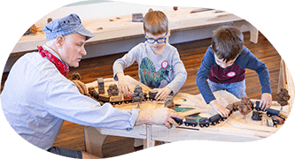 member of staff playing trains with children